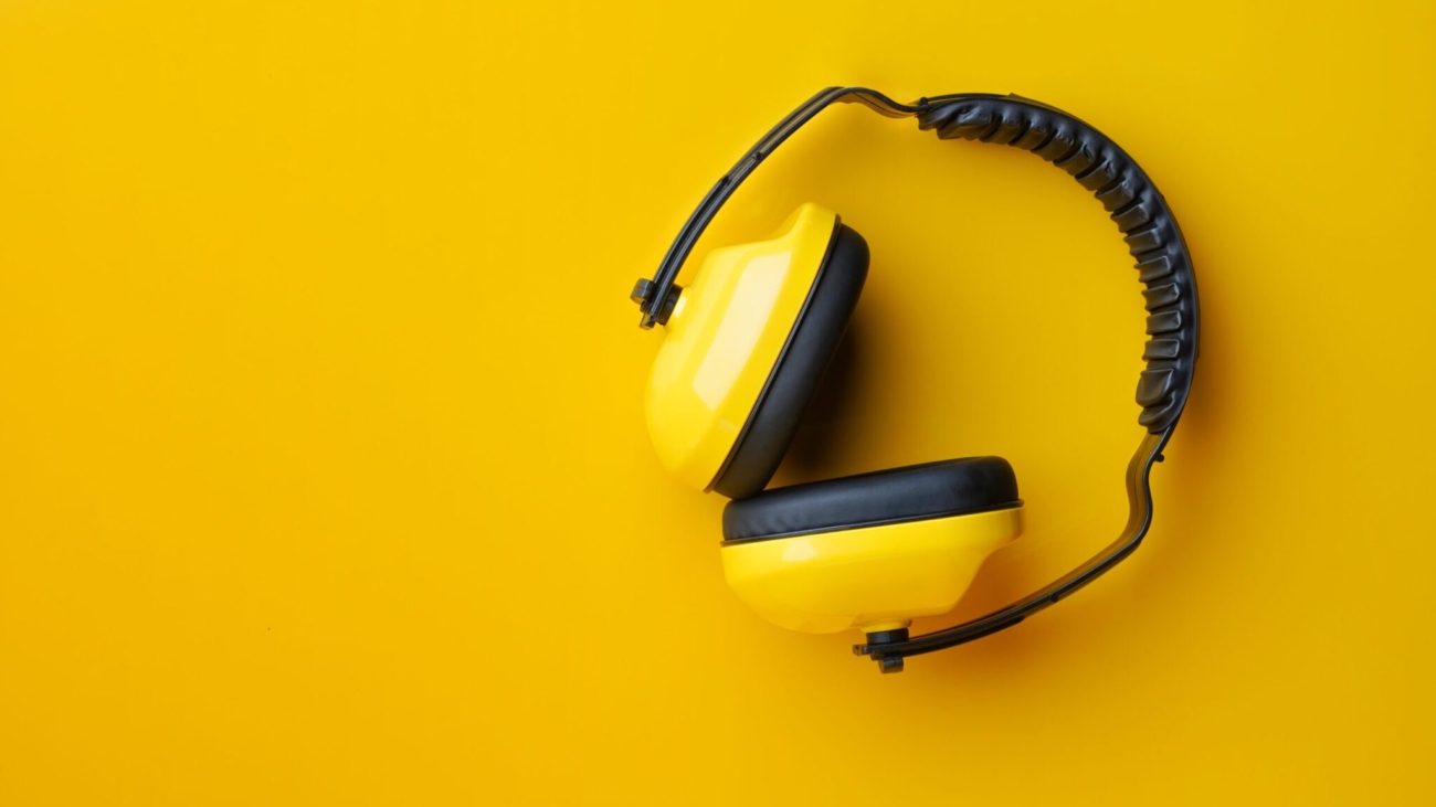 Protective ear muffs on yellow background .safety first concepts