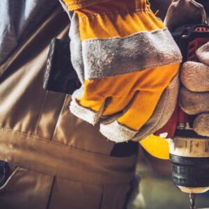 Hand with gloves holding a drill