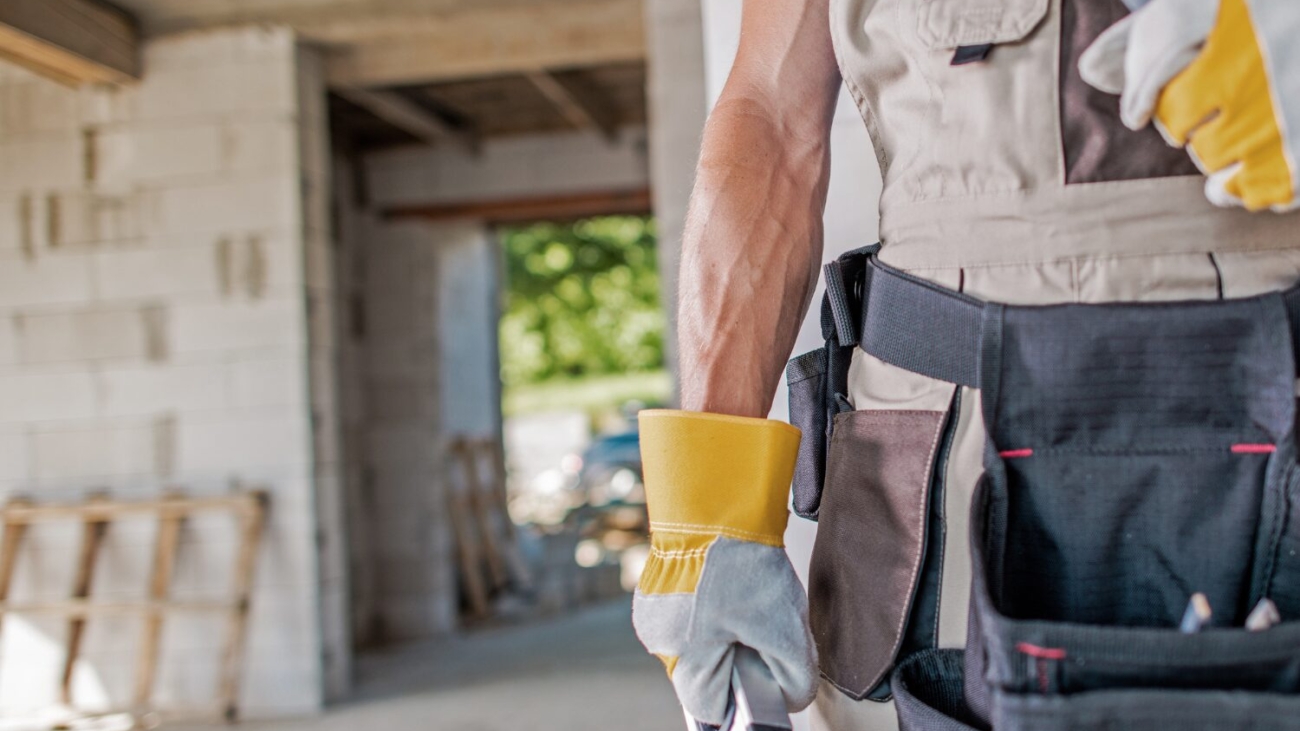 Man with gloves on holding tools