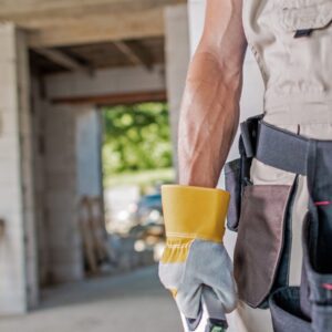 Man with gloves on holding tools