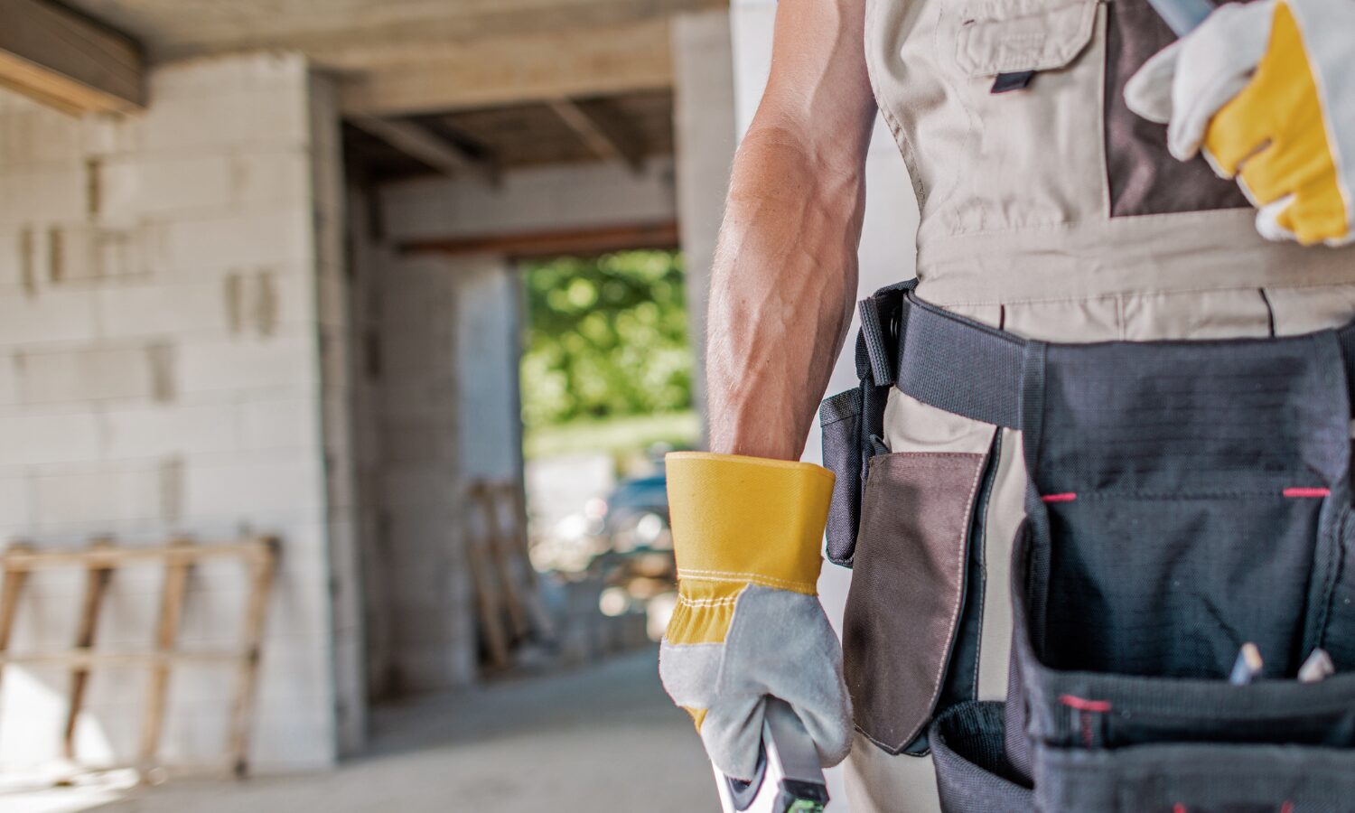 Man with gloves on holding tools